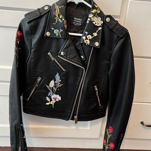 NBW black faux leather jacket with floral details.